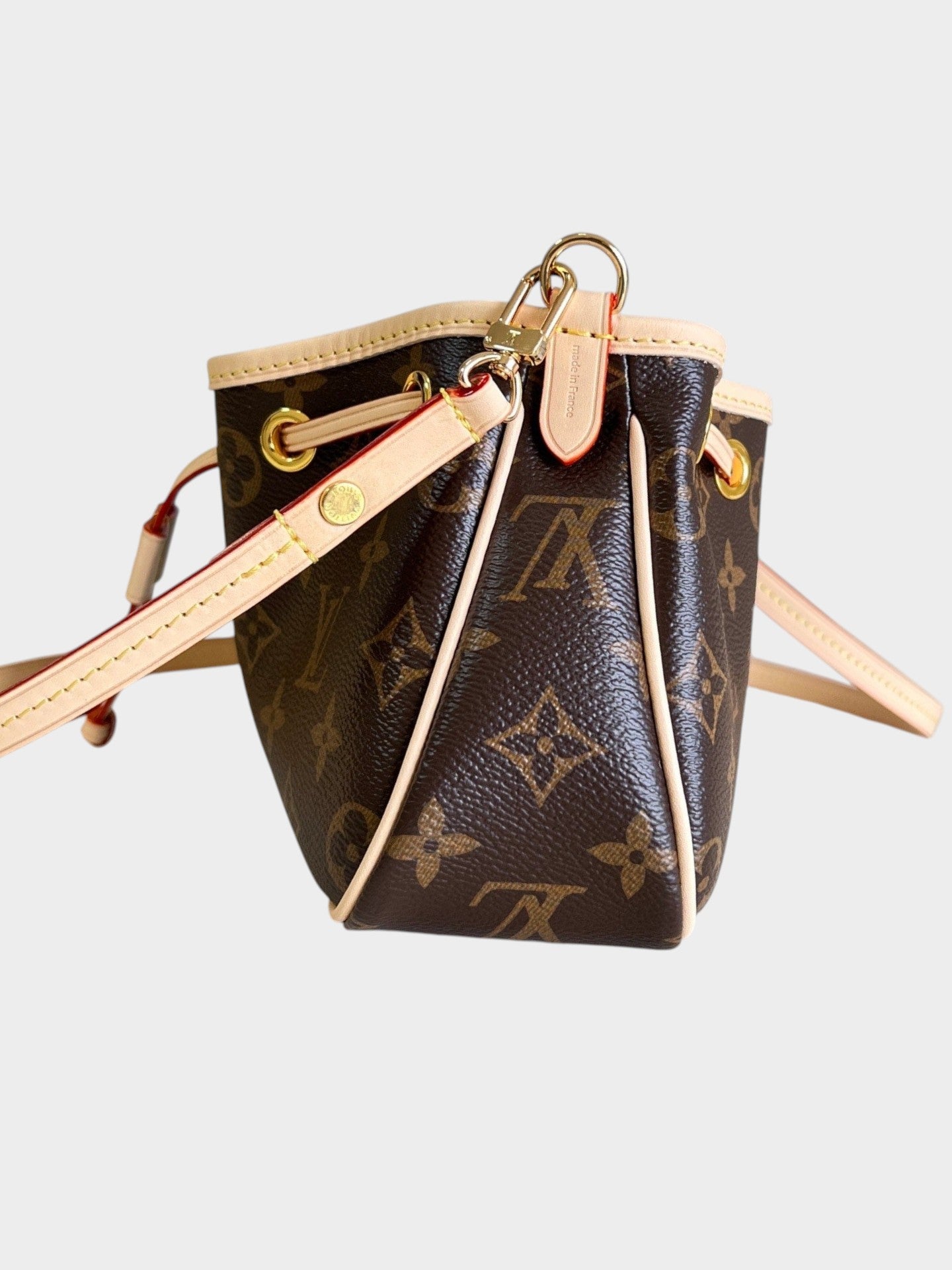 Zebass Louis Vuitton monogram canvas bucket bag with light leather trim, gold hardware, and adjustable shoulder strap.
