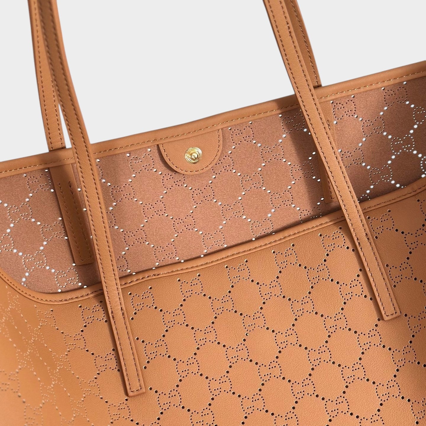 Zebass GUCCI tan leather tote bag with laser-cut monogram pattern, shoulder straps, and gold snap-button closure.