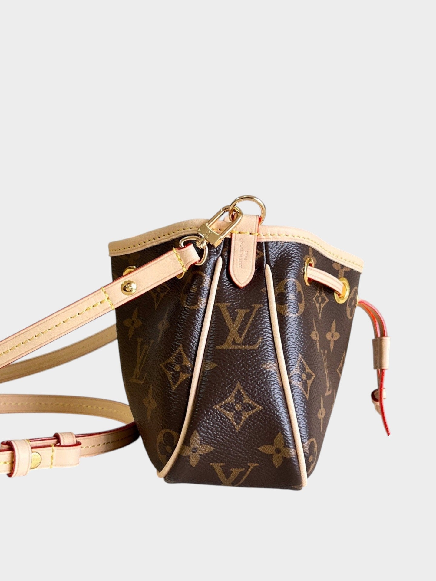 Zebass Louis Vuitton monogram canvas bucket bag with light leather trim, gold hardware, and drawstring closure.