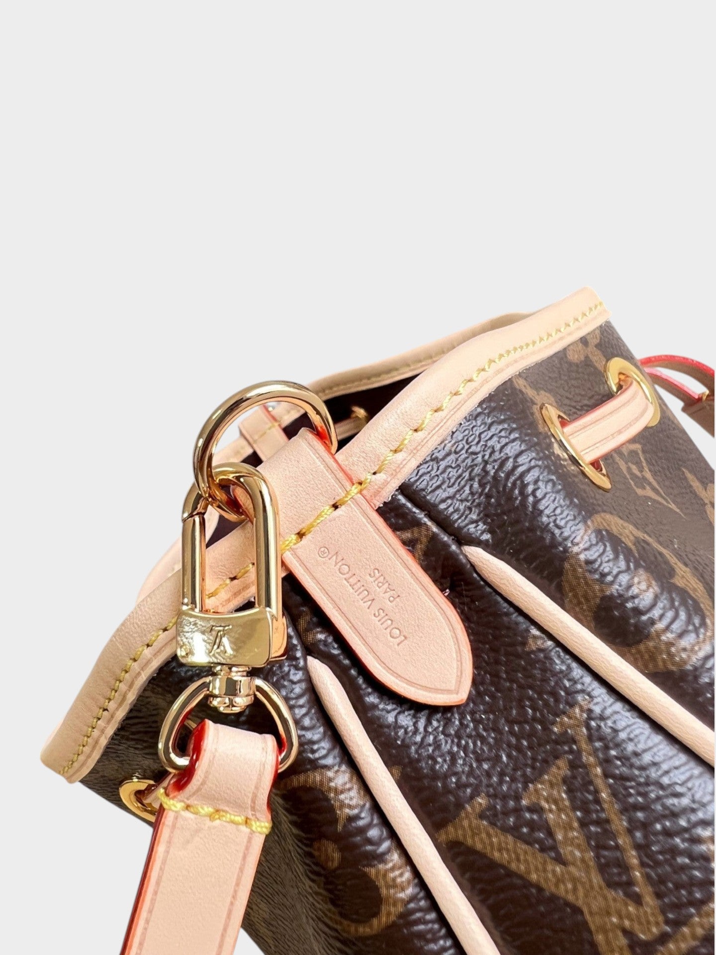 Zebass Louis Vuitton monogram canvas bucket bag with light leather trim, gold-tone hardware, and drawstring closure.